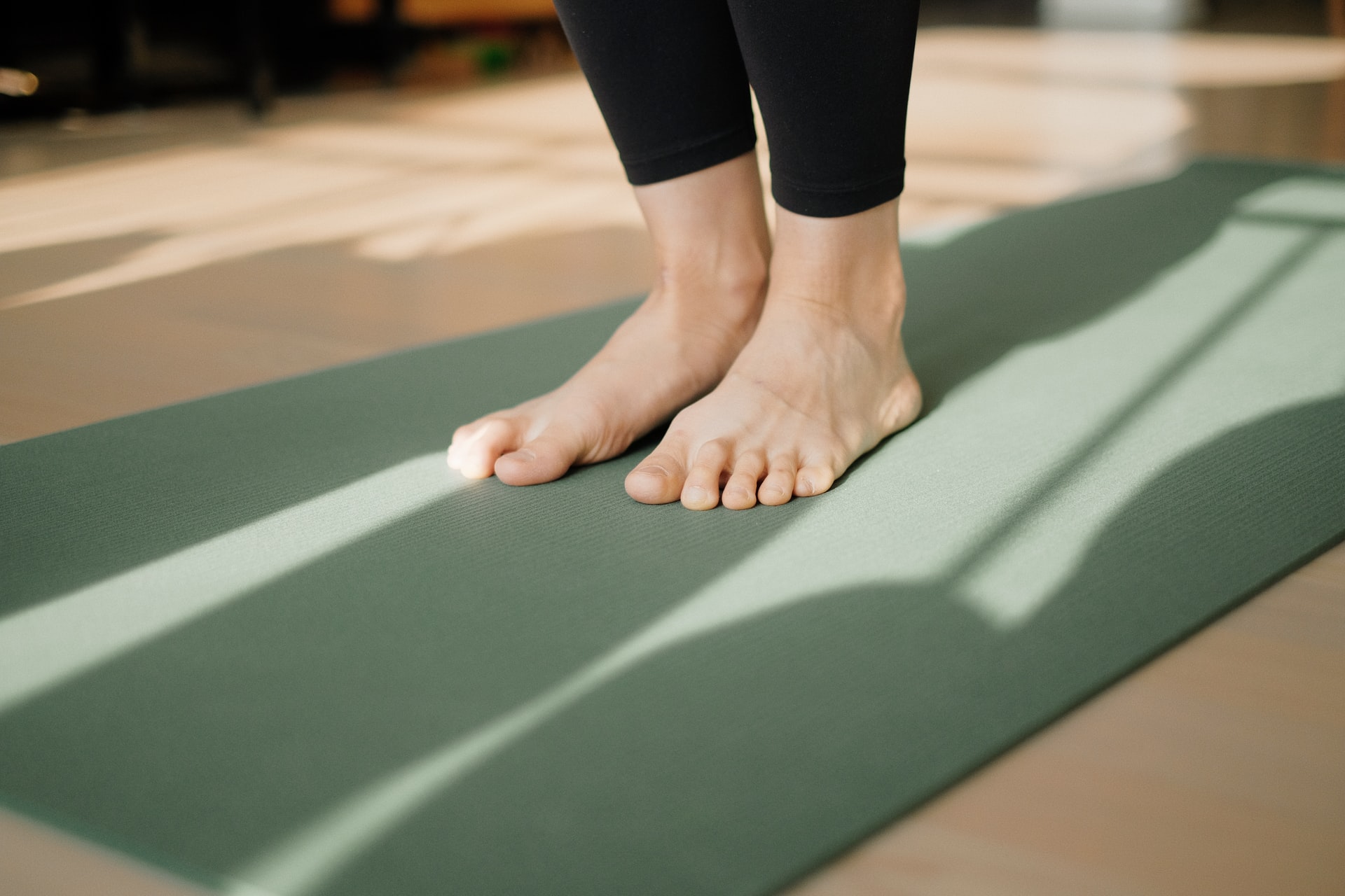 Füße stehen auf einer grünen Yoga-Matte bei einem Feldenkrais-Kurs in Wennigsen & Hannover